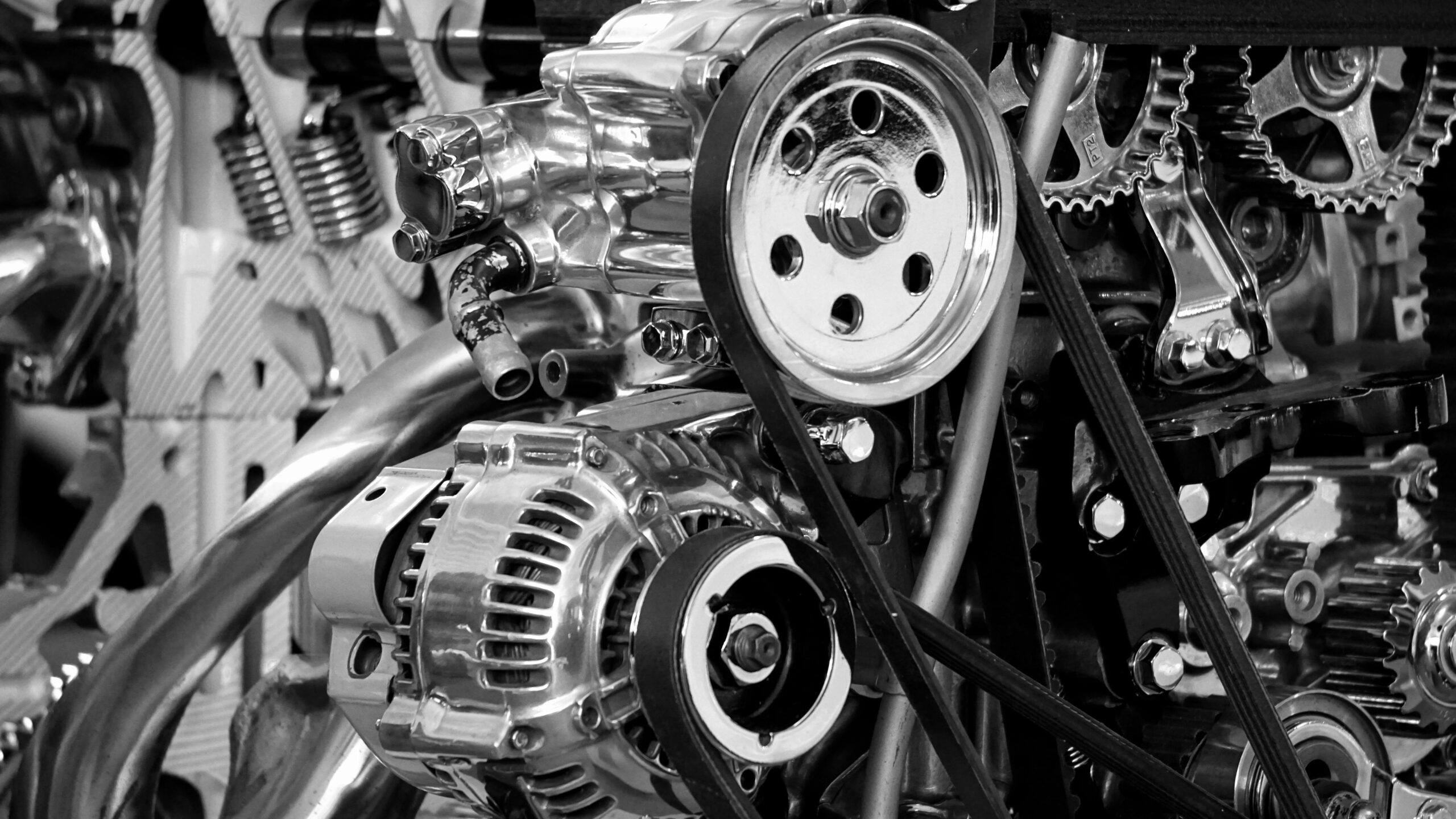 Close-up of polished car engine components in black and white.