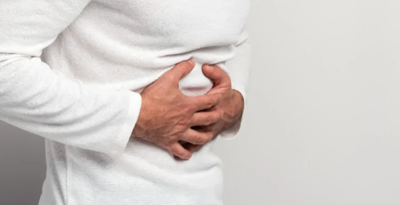 Person clutching their abdomen suggesting stomach pain or discomfort.
