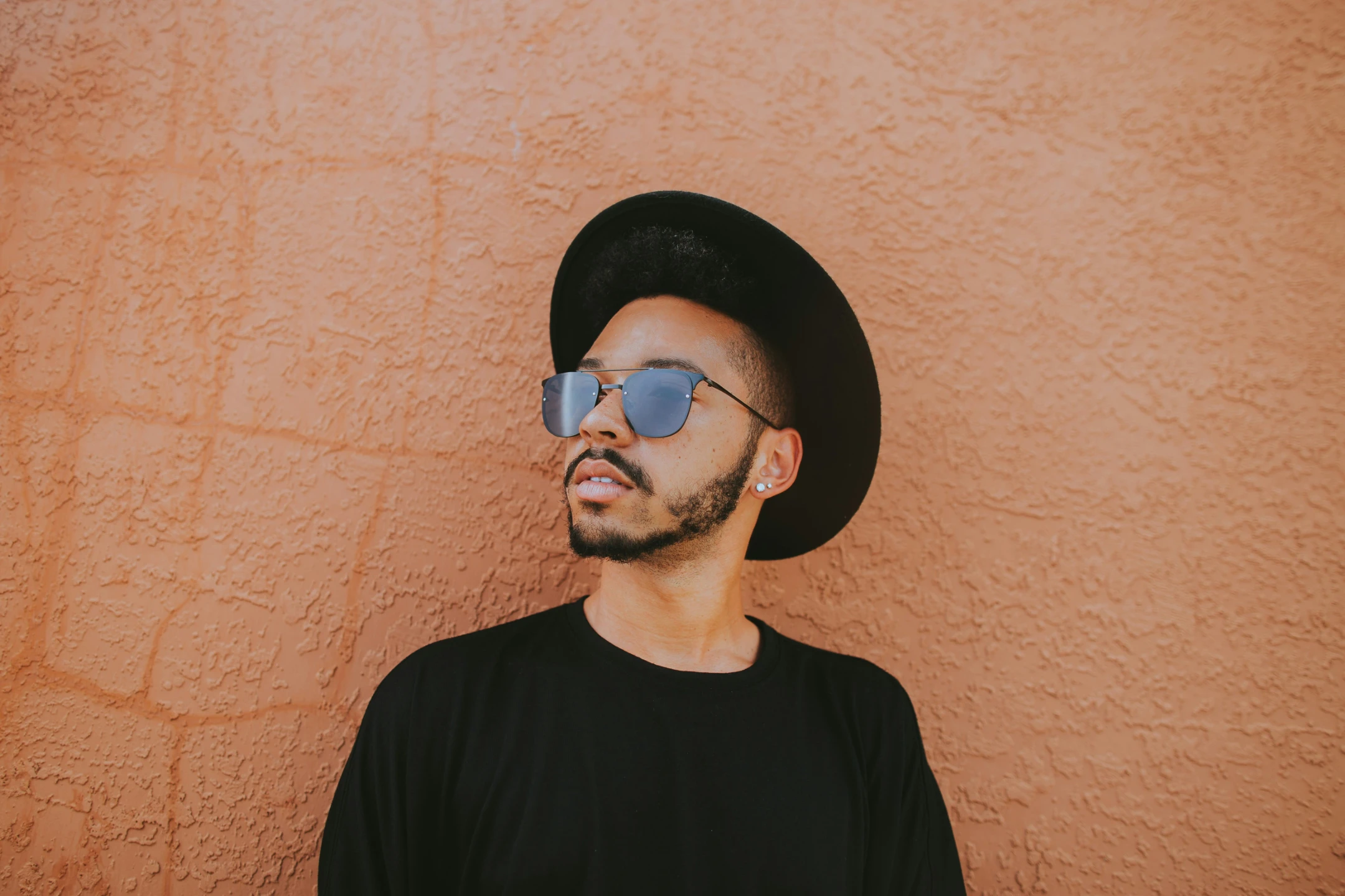 Stylish man wearing a black hat and sunglasses.